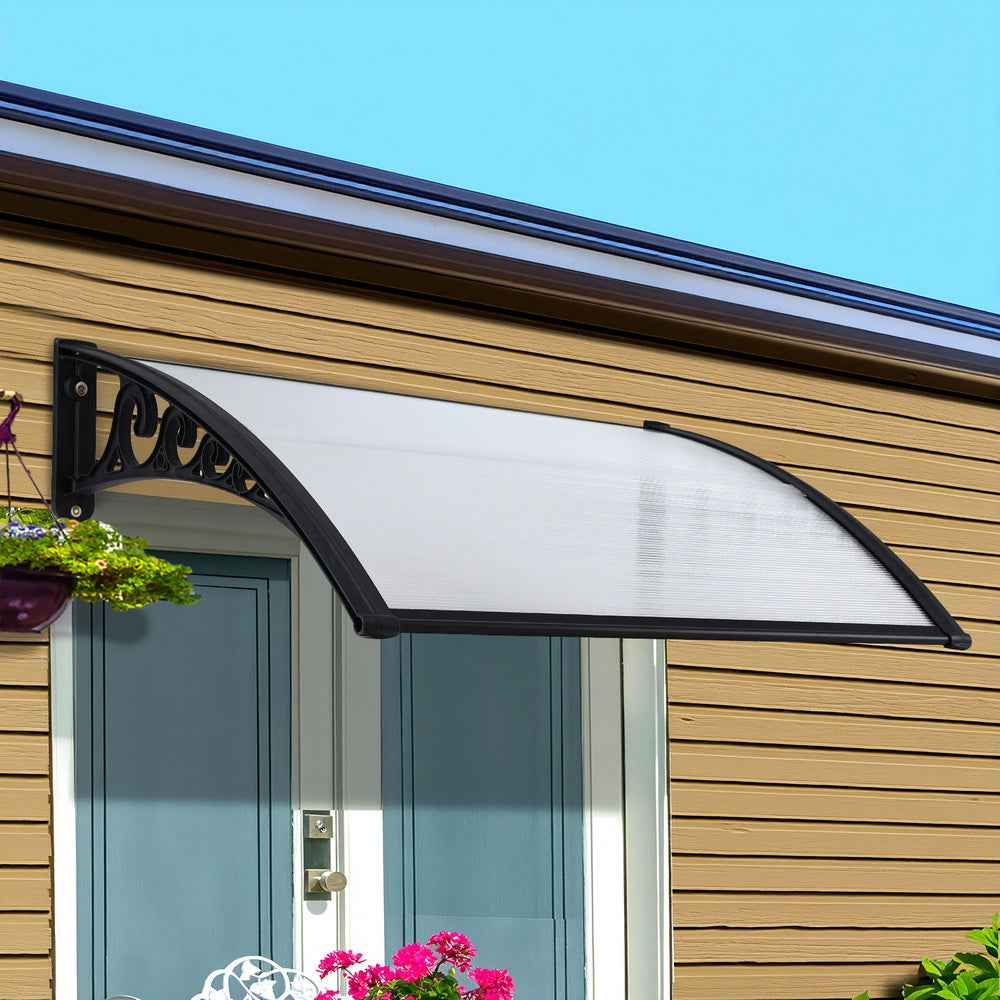 Transparent window door awning with black curved frame and clear panel above doorway