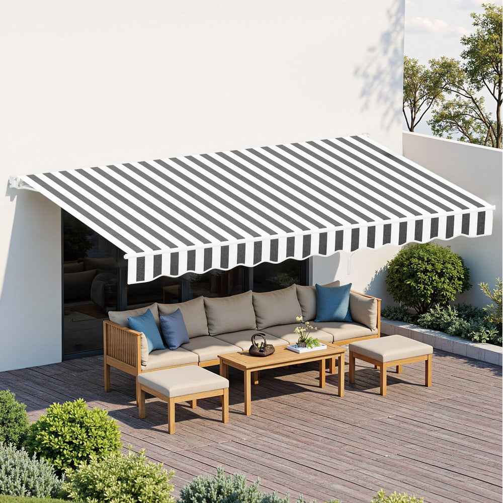Grey-and-white striped retractable awning over outdoor seating on a terrace