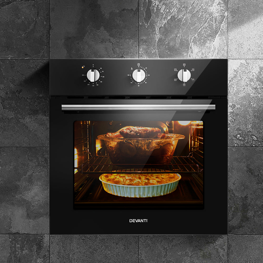 Electric built-in wall oven with interior light and food in a baking dish