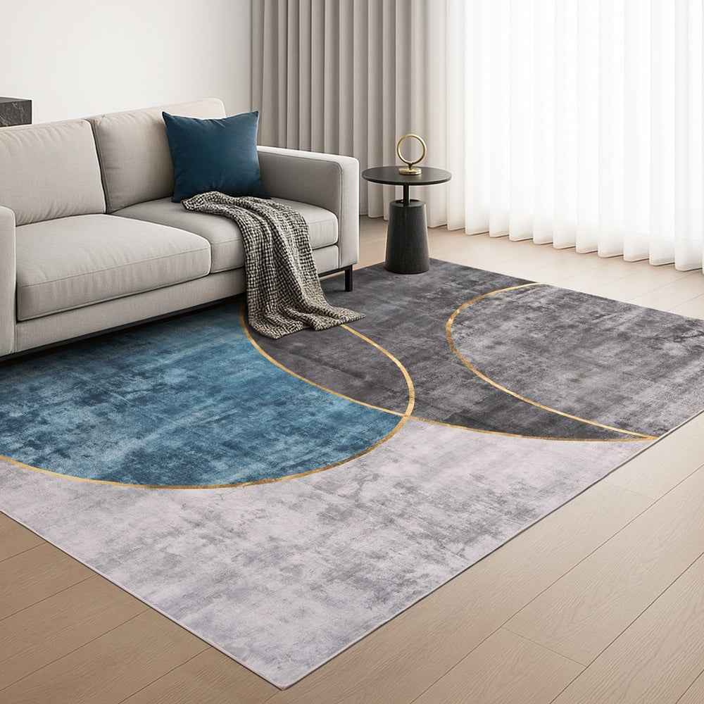 Large geometric area rug in blue and charcoal with curved oval lines and gold border