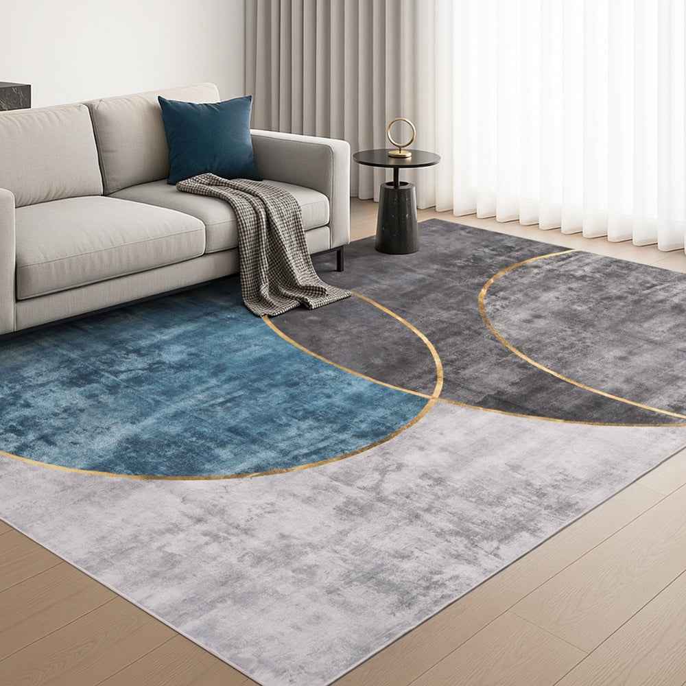 Modern geometric area rug in blue and charcoal with thin gold arc outlines
