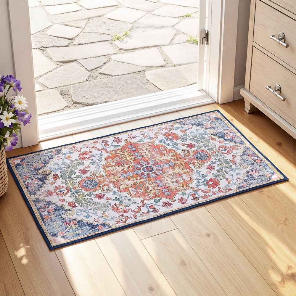 Rectangular blue short-pile floor rug with vintage medallion pattern and dark border at entry