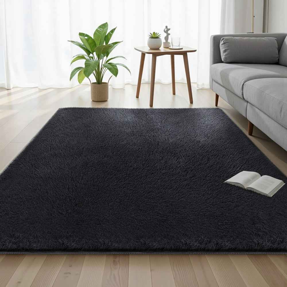 Black shaggy area rug, rectangular plush pile laid on light wooden floor