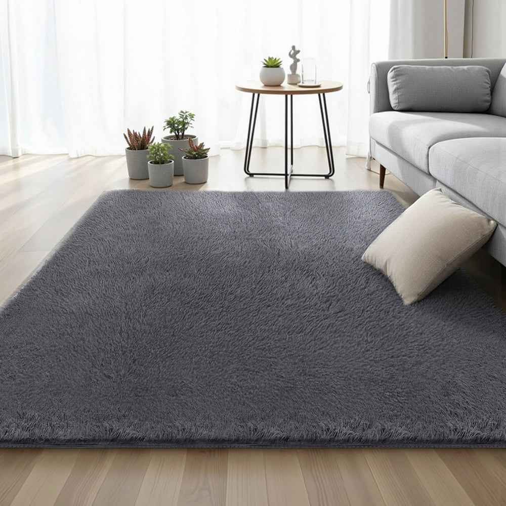 Grey shaggy area rug in living room setting, plush pile spread on floor