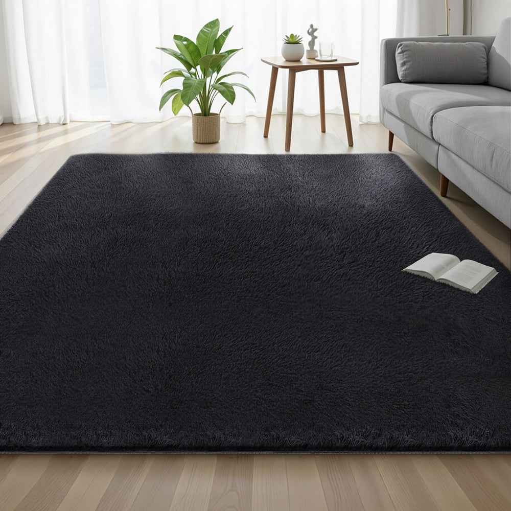 Black shag area rug laid flat on a wood floor