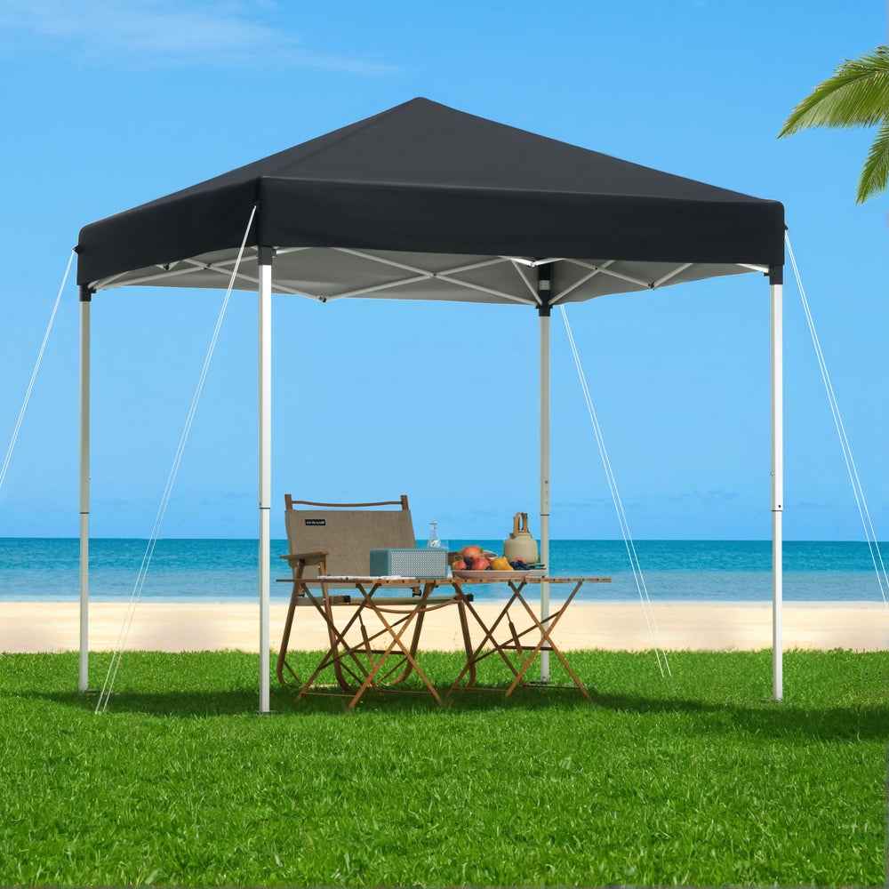 Black outdoor gazebo canopy over patio bench set with open sides