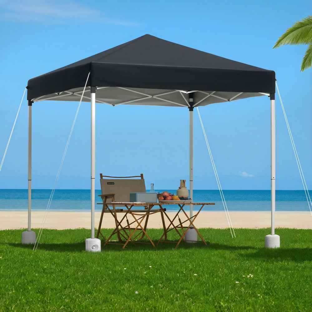 Black gazebo canopy with white frame and four corner base weights over seating