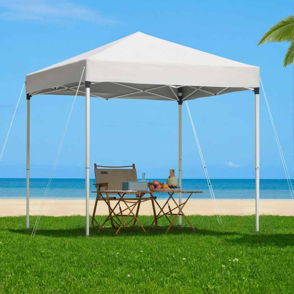 White outdoor gazebo with peaked canopy roof, four legs, and visible tie ropes