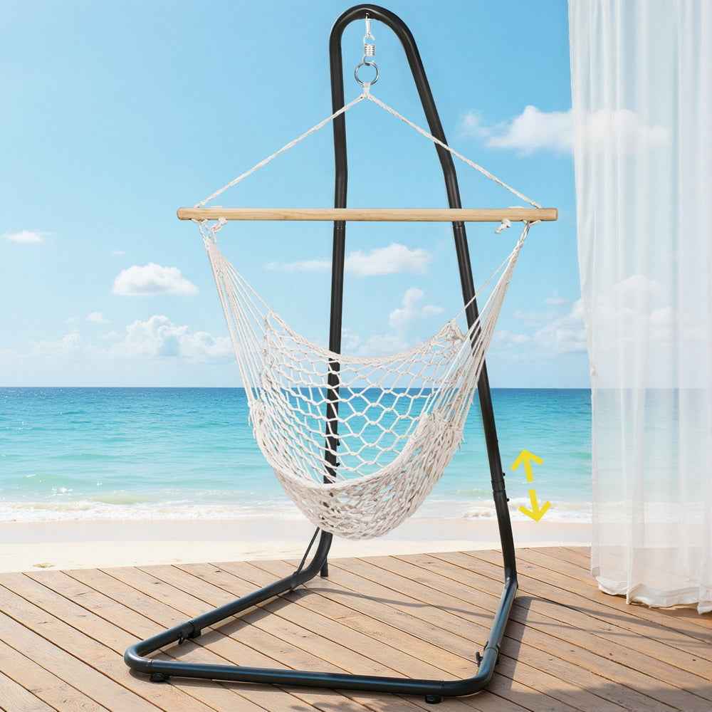 Hanging hammock chair with white rope net swing and black steel stand on deck
