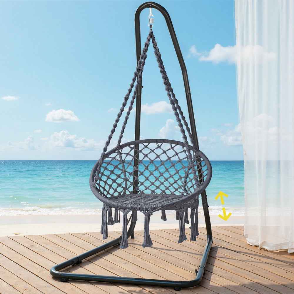 Black hanging hammock chair with rope net seat, steel stand base and fringed perimeter