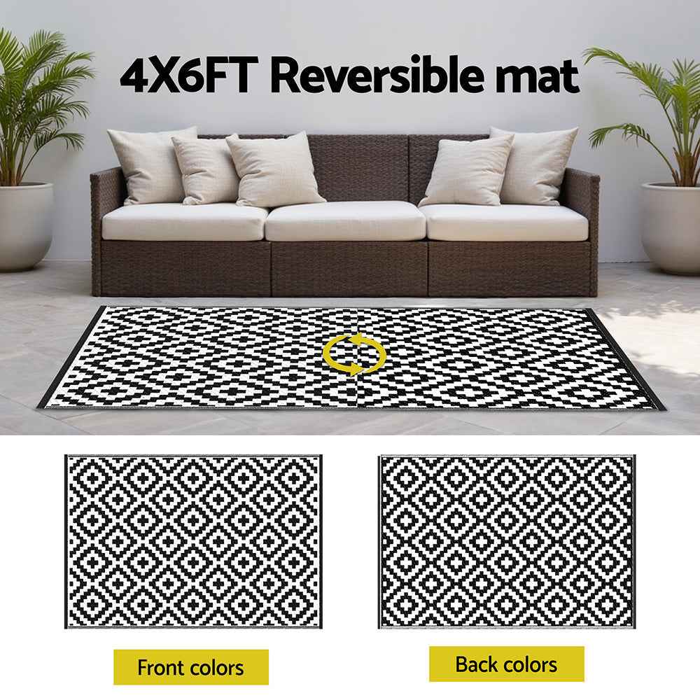 Reversible outdoor rug showing two sides in black-and-white geometric diamond pattern.