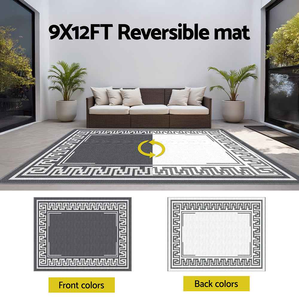 Reversible patio rug with dark gray center and white Greek key border, front and back