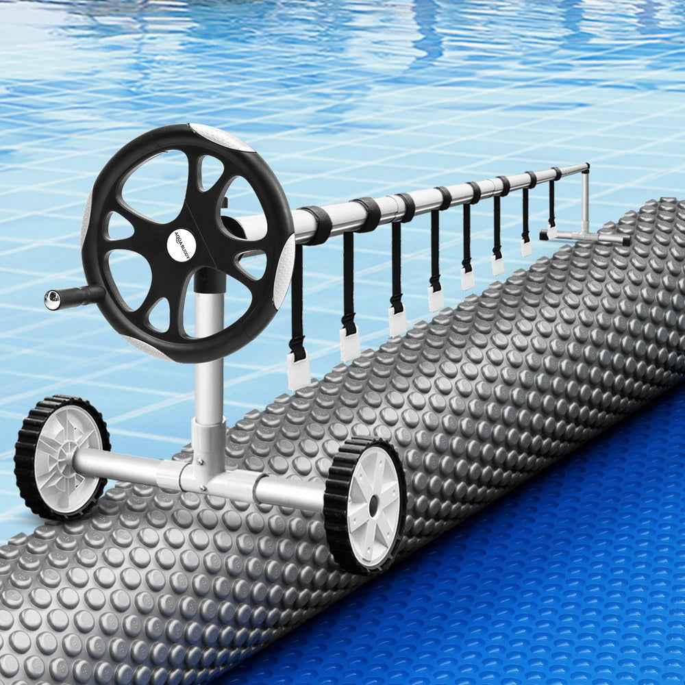 Solar pool heat blanket on roller with gray bubbles and black reel wheels