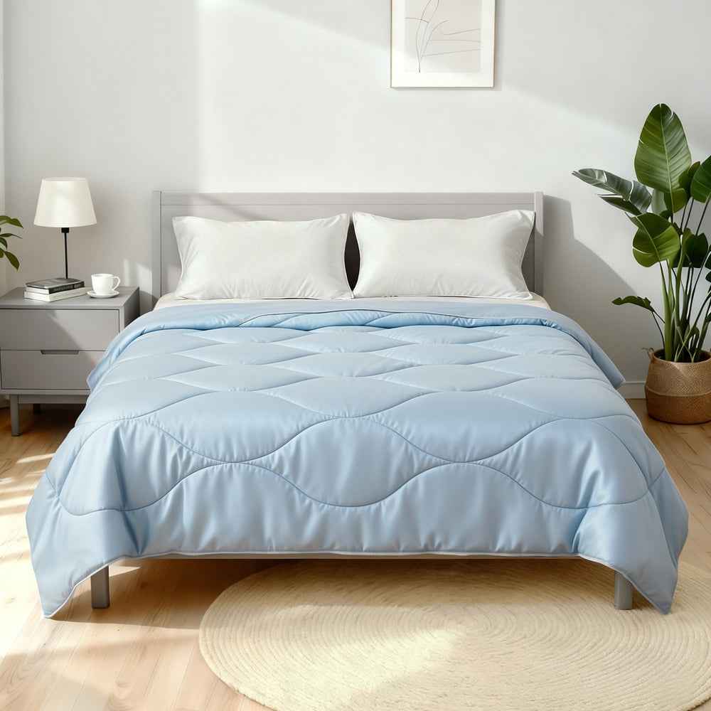 Light blue queen quilt comforter with channel stitching on bed