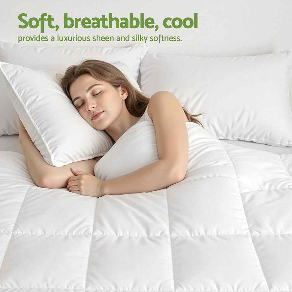 White quilt on bed with stitched baffle squares, woman resting