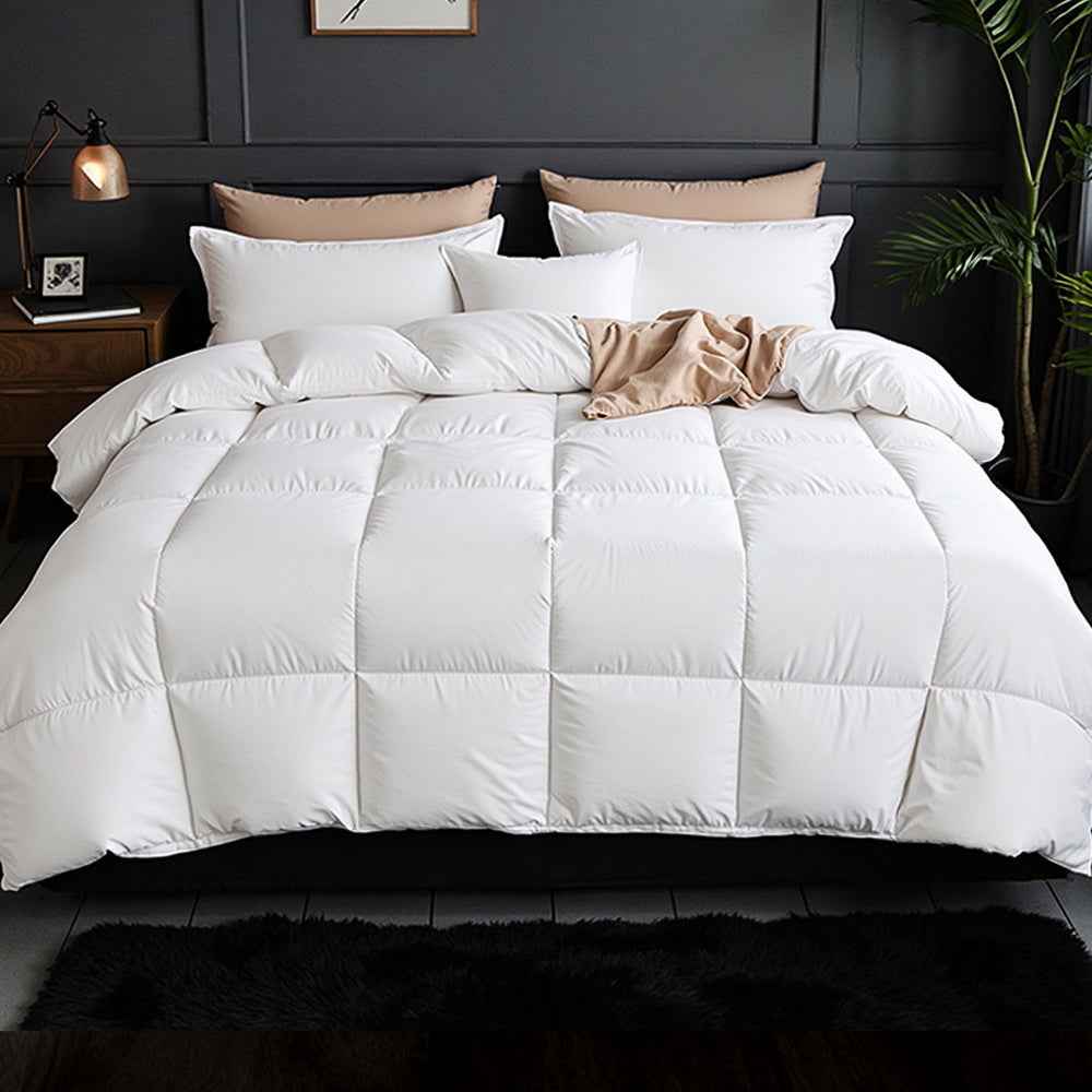 White quilted goose down comforter with puffed baffle sections on a bed