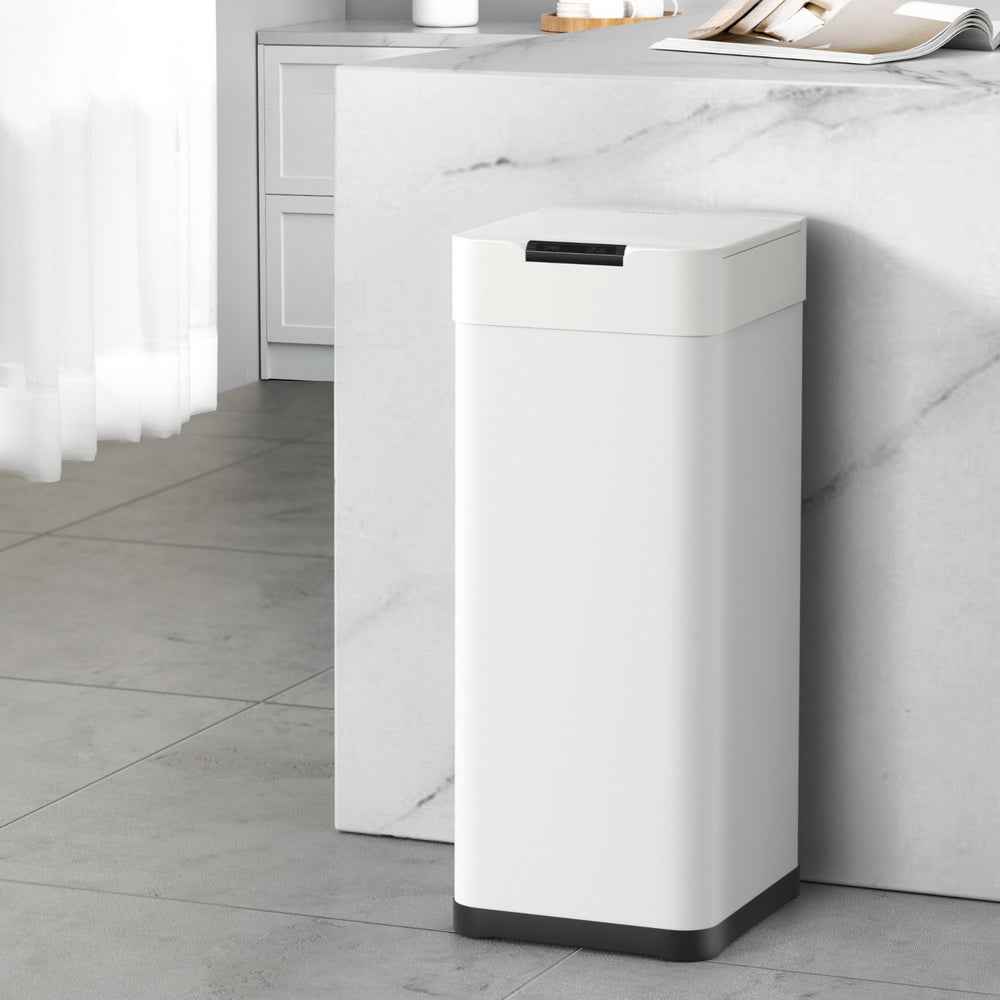 White automatic sensor trash can standing with black top cover and dark base
