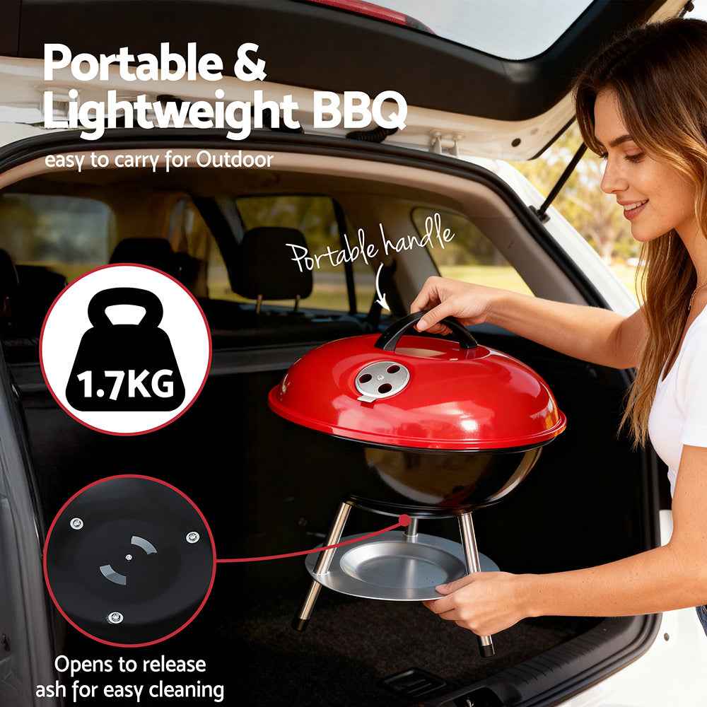 Portable charcoal BBQ grill in car trunk with red lid and black cooking bowl