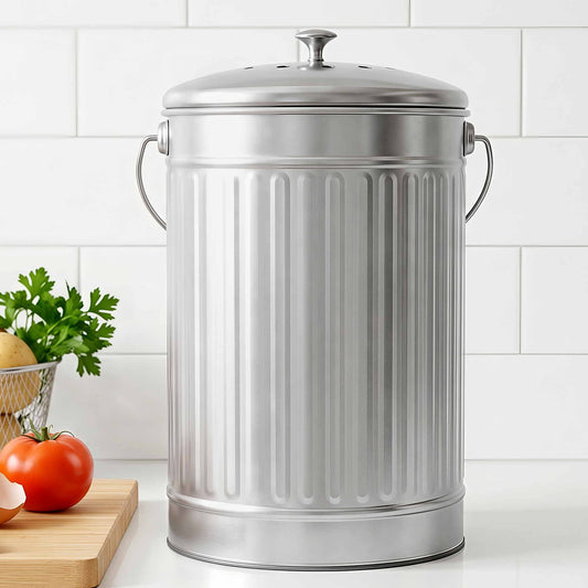 Silver compost bin with domed lid and side handles, ribbed metal sides on kitchen counter