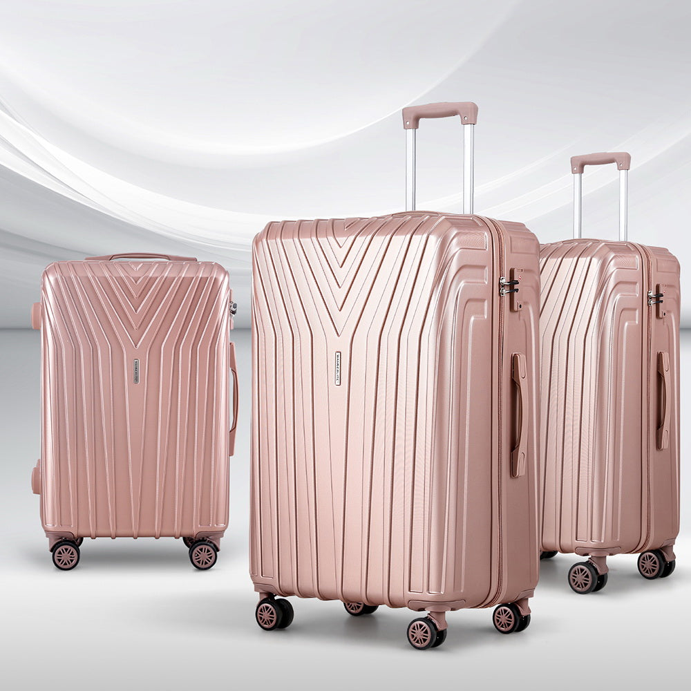 Pink hard-shell luggage set with three suitcases, upright with spinner wheels and handles