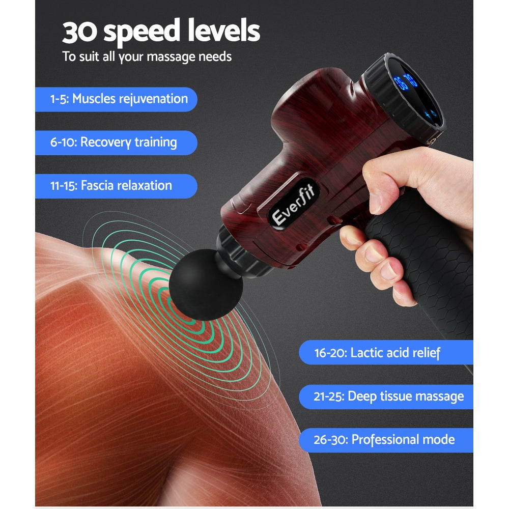 Red handheld massage gun held to leg with black round massage head