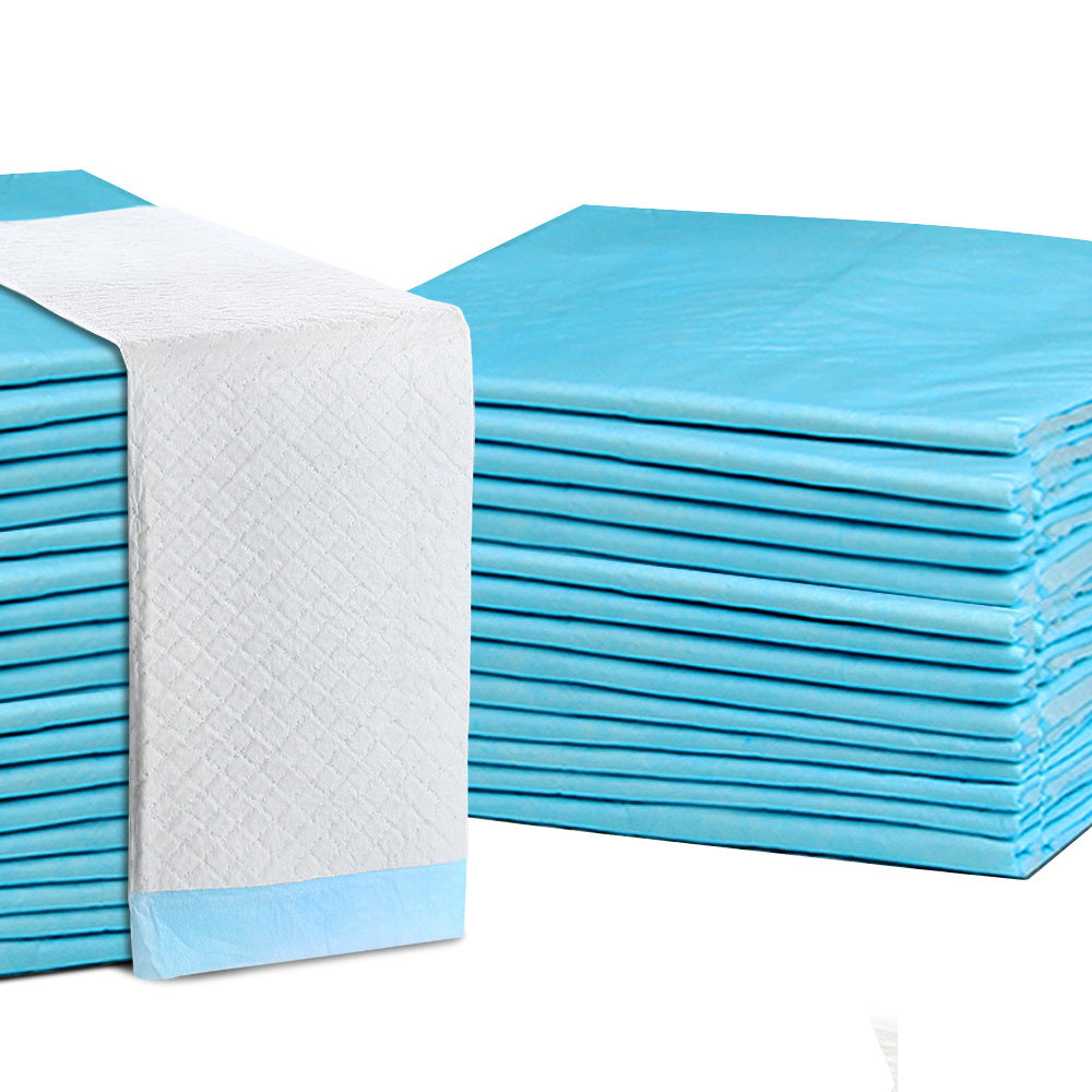 Stack of blue and white training pads with quilted absorbent surface